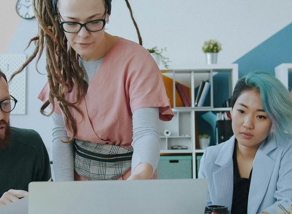 Un equipo revisa algo junto alrededor de una laptop